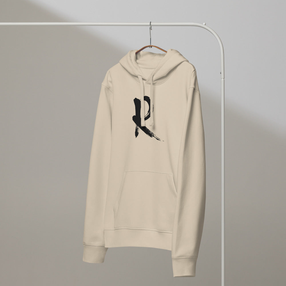 A minimalist sumi-e brush stroke design of the capital letter R printed on a hoodie. On a hanger, Clay colourway.