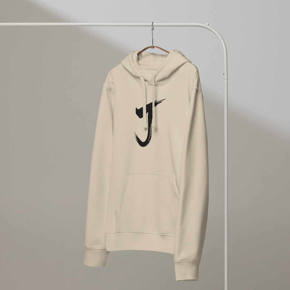 The letter J rendered in a single black sumi-e brush gesture, printed on a hoodie. On a hanger, Clay colourway.