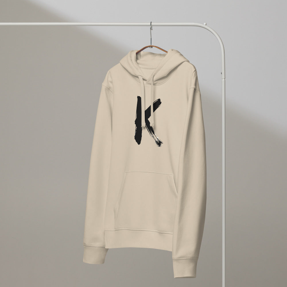 Sumi-e ink brush painting of the capital letter K printed on a hoodie. On a hanger, Clay colourway.