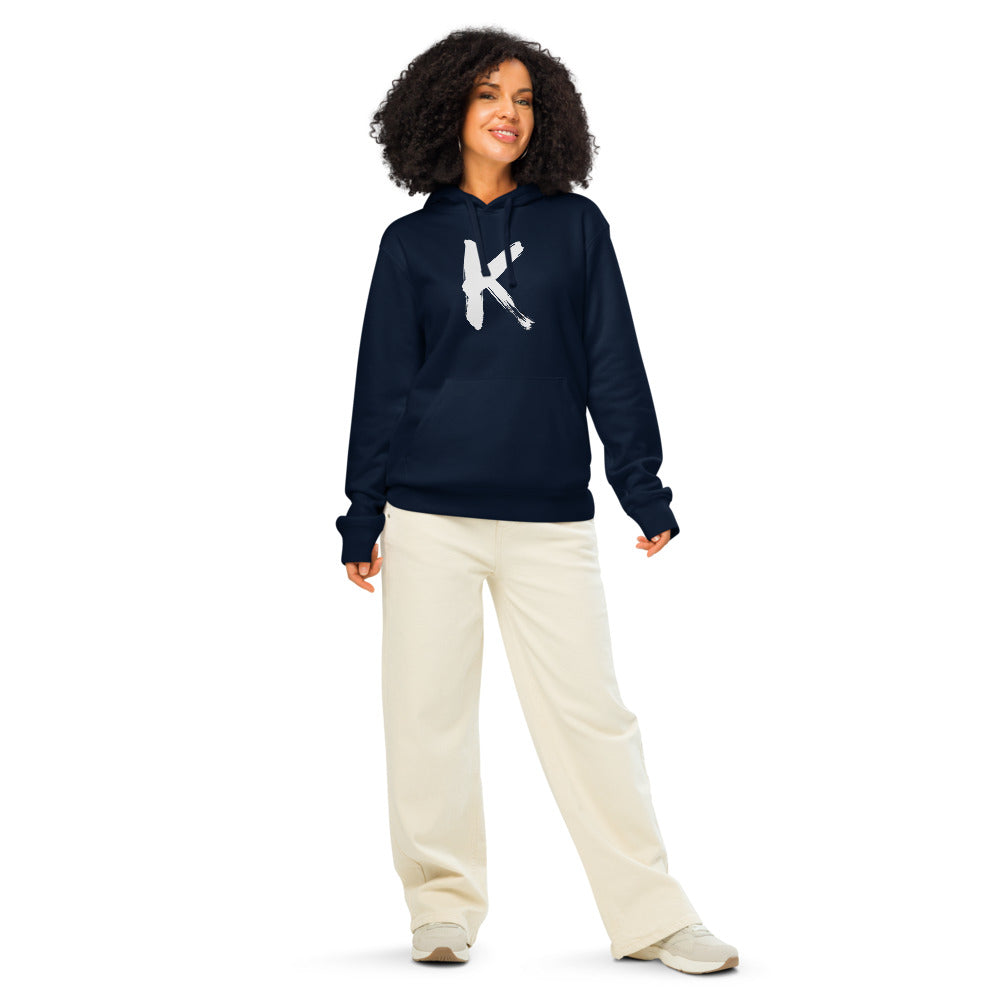 Sumi-e ink brush painting of the capital letter K printed on a hoodie. Worn by a woman, Ink colourway.